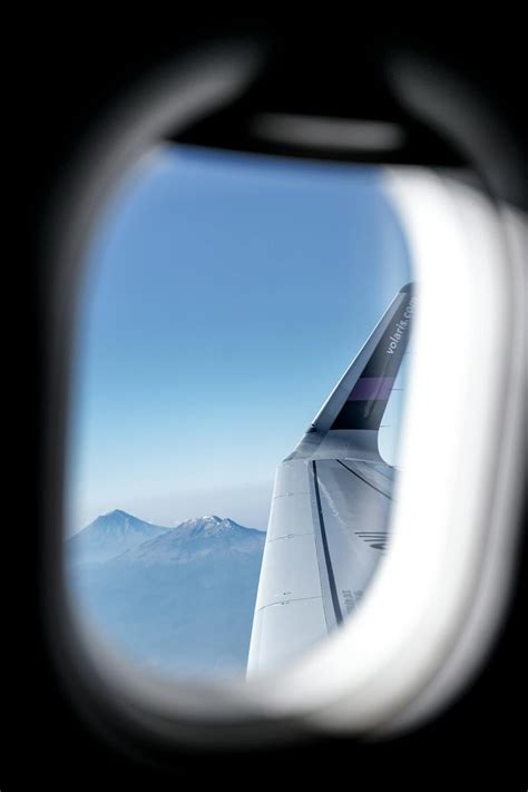 Airplane Window View of Snow Covered Mountains · Free Stock Photo