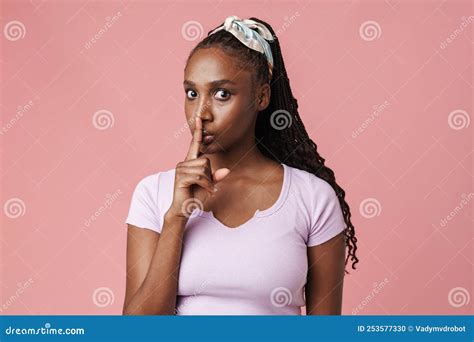 Black Surprised Woman With Pigtails Showing Silence Gesture Stock Photo