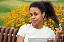 Portrait Of Black Female Sitting On Bench In Front Of Flowers Free