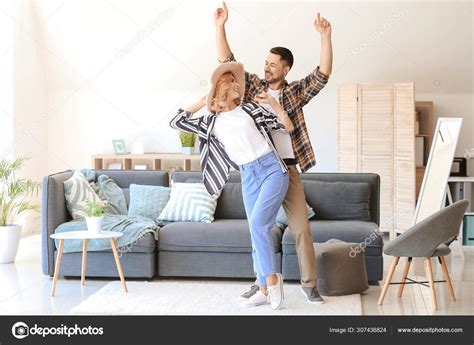 Happy dancing couple at home Stock Photo by ©serezniy 307436824