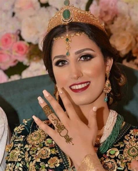 A Woman Wearing A Tiara And Holding Her Hand Up To Her Face With