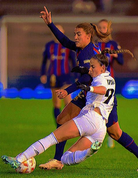 Two Women Are Playing Soccer On The Field