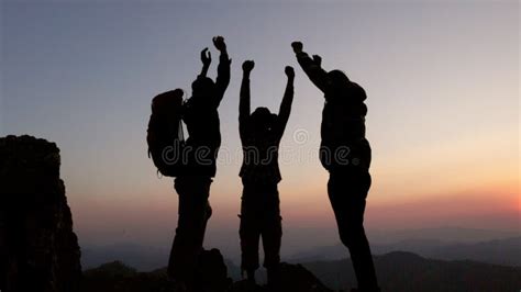 Silhouettes Of A Group Of Successful Climbers On The Top Of A Mountain