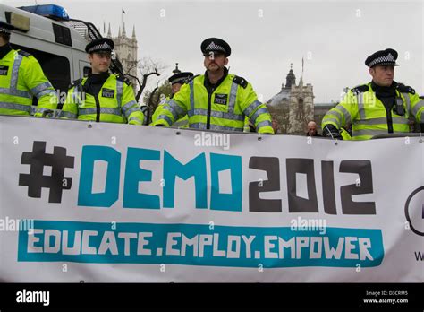 four police officers stand behind a protest barrier during a student ...