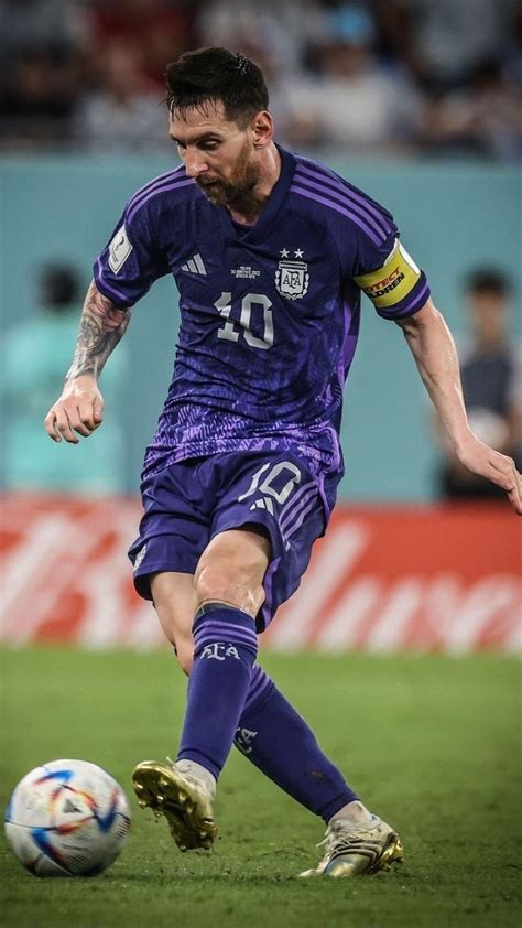 A Man Kicking A Soccer Ball On Top Of A Field