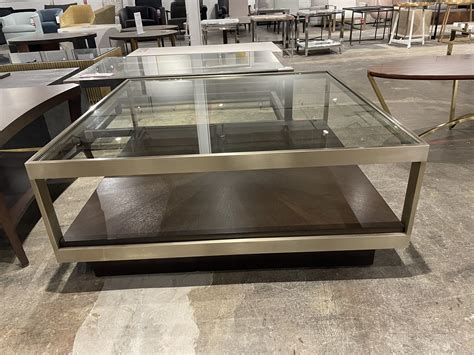 A Table With Glass Top And Metal Frame In A Room Filled With Tables