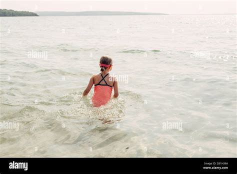 Petite jeune fille nageant dans la rivière du lac avec des lunettes