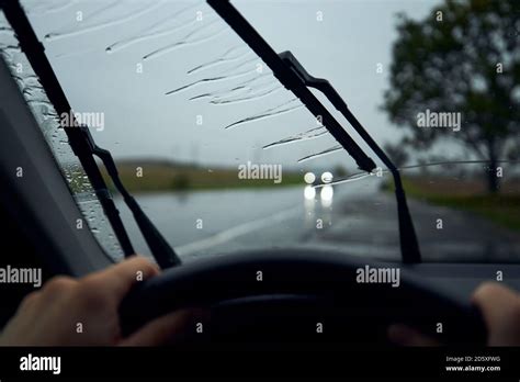 Driving In Heavy Rain Raindrops On Windshield Of Car Against Traffic