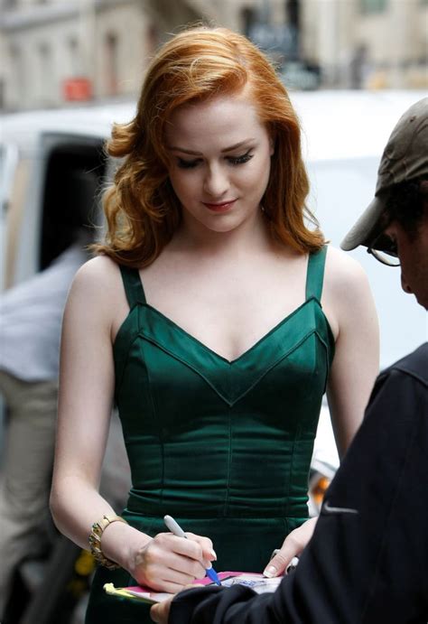 A Woman In A Green Dress Is Writing Something On Her Paper While