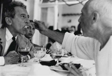 An Old Photo Of Two Men Eating At A Table