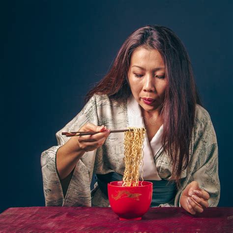 Beautiful Asian Woman Eating Asian Noodles With Wood Chopsticks Dark