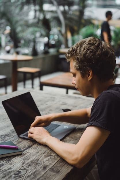 Homme travaillant avec un ordinateur portable dans un café sur une