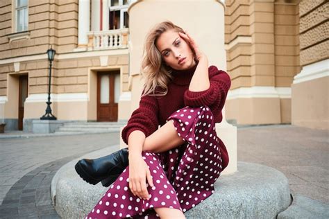 Superbe fille blonde élégante en pull tricoté regardant en toute