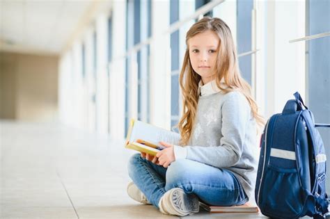 Menina sorrindo linda colegial sorrindo enquanto está sentado perto da