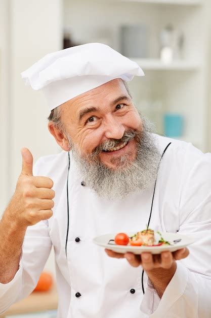 Premium Photo Smiling Chef Presenting Dish