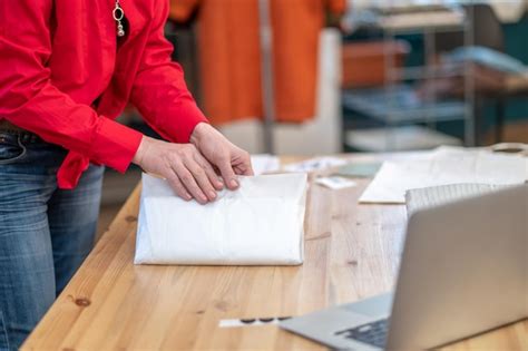 Premium Photo Womans Hands Holding Paper Package On Table