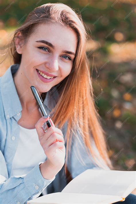 Free Photo Smiling Blonde Woman Holding A Pen