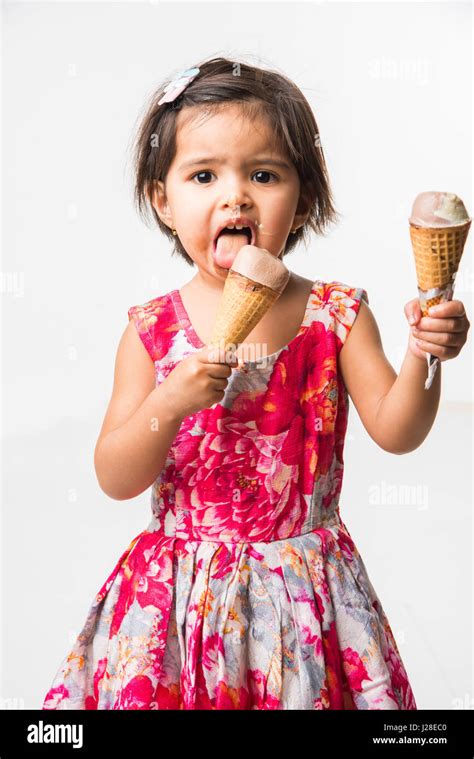 Indian Adorable Bebé O Niña Lamer O Comer Helado De Chocolate En El Cono Cono Y Mostrando