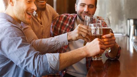 Alegr As Amigos Hombres Que Beben La Cerveza Y Que Tintinean Los