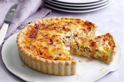 A Quiche On A Plate With A Slice Missing