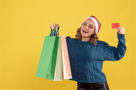 Jovem segurando o cartão do banco e pacotes depois de fazer compras no