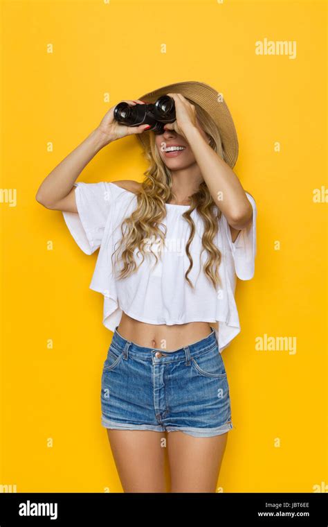 Blond Young Woman In Jeans Shorts White Shirt And Straw Hat Looking