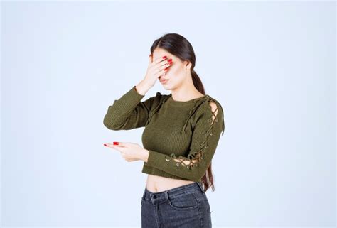 Modèle De Jeune Femme Couvrant Ses Yeux Avec Une Main Et Pointant Vers