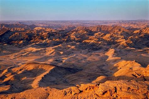 An Aerial View Of The Desert With Mountains In The Foreground And Blue