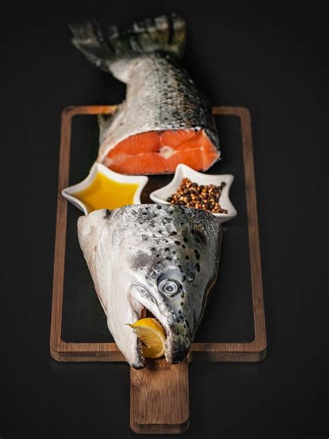 Fresh Salmon Fish Head And Tail On A Cutting Board On A Dark