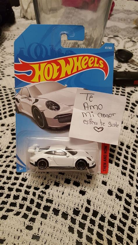 A White Hot Wheels Car With A Note Attached To It S Back End On A Table