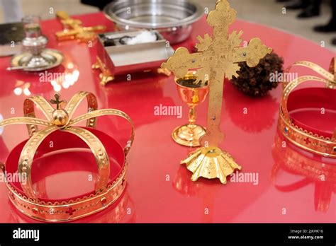 A Golden Cross Crowns Chalice And Paten On A Red Church Table