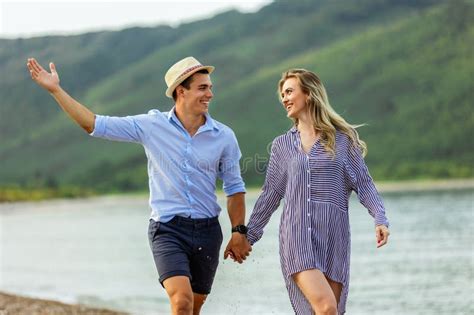 Pareja Feliz Ri Ndose Y Abraz Ndose En La Playa Imagen De Archivo