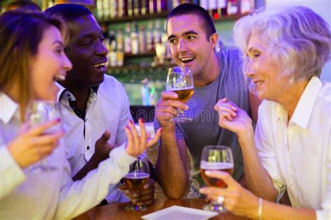 Companhia De Amigos Multirraciais Bebendo Cerveja E Conversando Entre