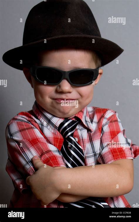 The boy in a hat and black glasses on a gray background Stock Photo - Alamy