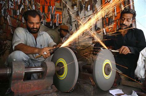 Blacksmith Busy In Sharpening Knives To Be Used During The Procession