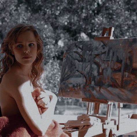 A Naked Woman Sitting In Front Of An Easel