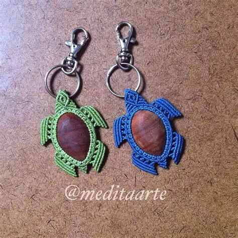 Two Crocheted Turtle Keychains With Wood In The Middle On A Brown Surface