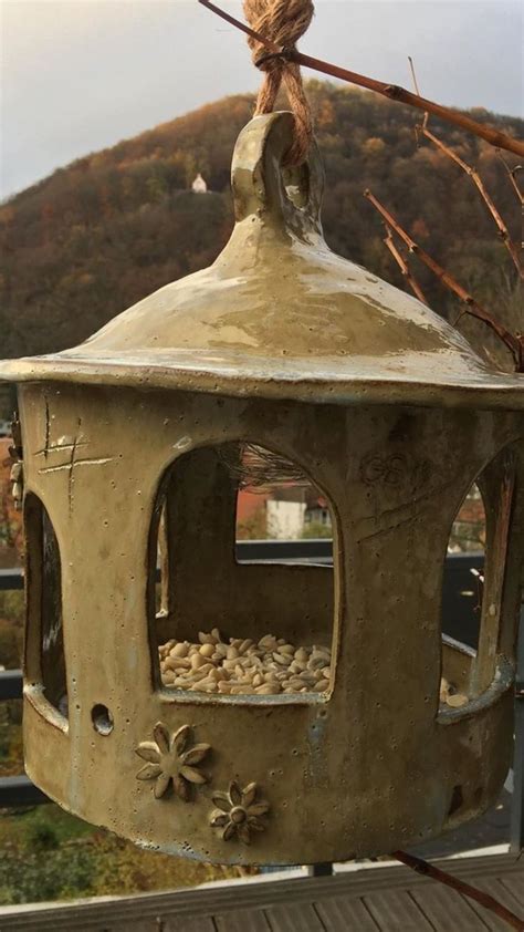 A Bird Feeder Made Out Of Clay With Birds Perched On It S Roof And