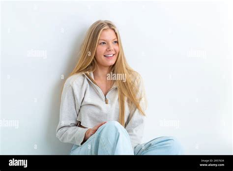 Portrait Of A 19 Year Old Blonde Woman Leaning Against A White