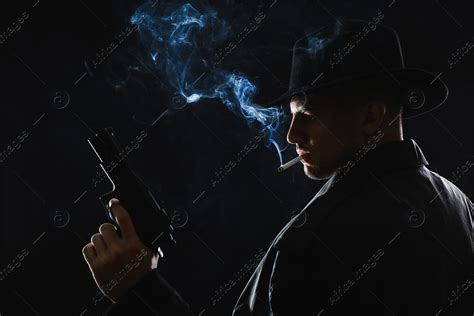 Old Fashioned Detective With Gun Smoking Cigarette On Dark Background