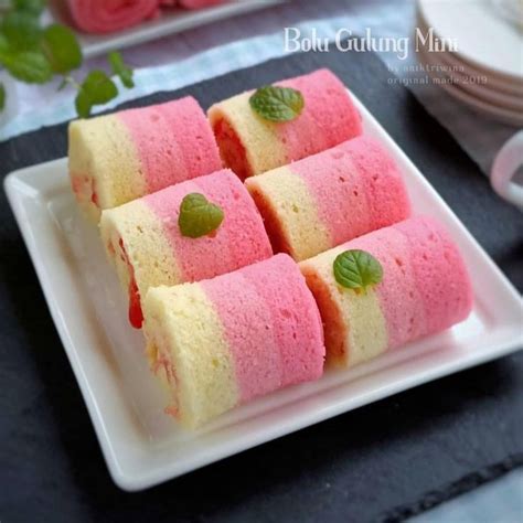 There Are Many Small Desserts On The Table With Pink And Yellow Frosted