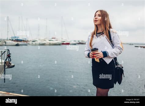 College Woman Student Of Marine Academy Drinking Coffee By Sea Wearing