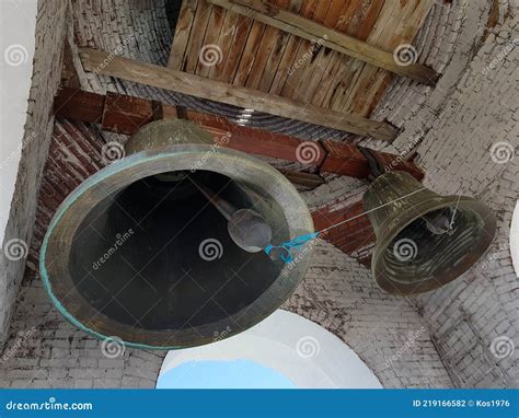 Large Church Bells Hang Under The Arch Of The Bell Tower Stock Photo