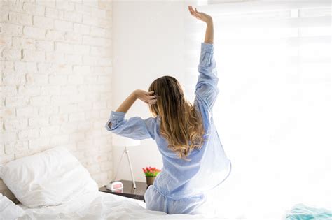 Premium Photo Rear View Of A Pretty Young Woman Sitting On Her Bed