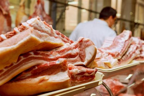 Carnicero Masculino Cortando Carne Cruda Con Cuchillo En Mostrador En