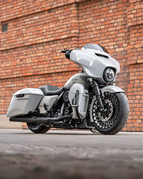 a silver motorcycle parked in front of a brick building