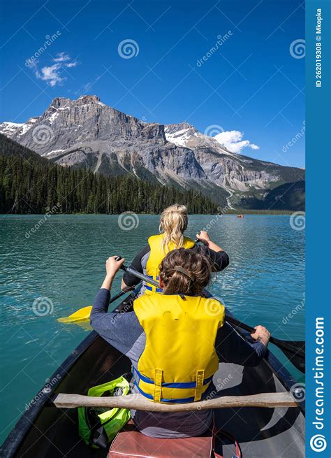 Two Women Paddle On A Canoe On Emerald Lake In Yoho National Park