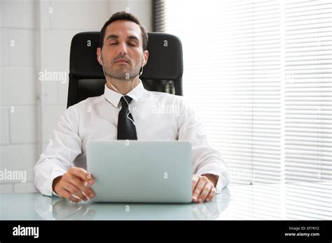 Half Length Portrait Of A Male Businessman With Eyes Closed Earphones