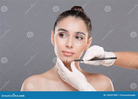 Doctor Marking Young Woman Face Before Cosmetic Surgery Stock Photo