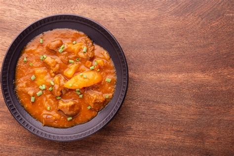 Premium Photo Plate With Cooked Cassava And Meat On Wooden Table